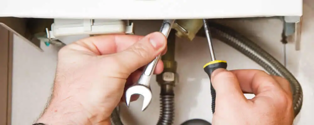 Boiler repair technician tightening pipe fittings and connections in Virginia Beach, VA