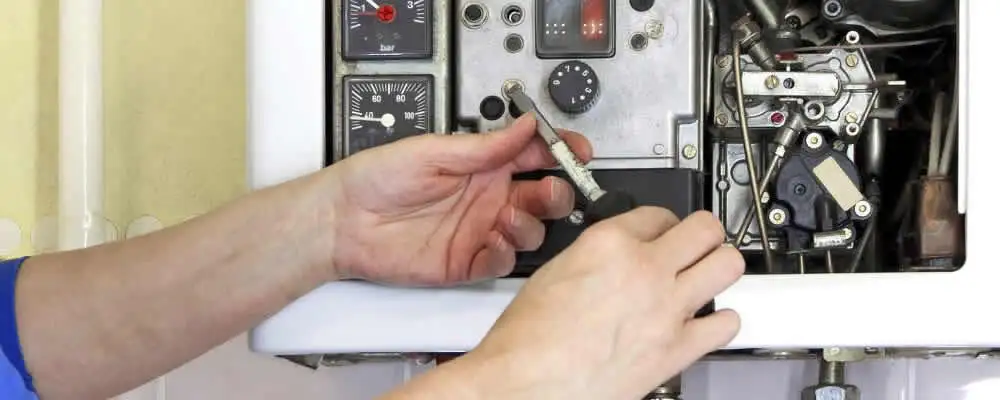 Heating repair technician adjusting boiler controls and components in Virginia Beach, VA