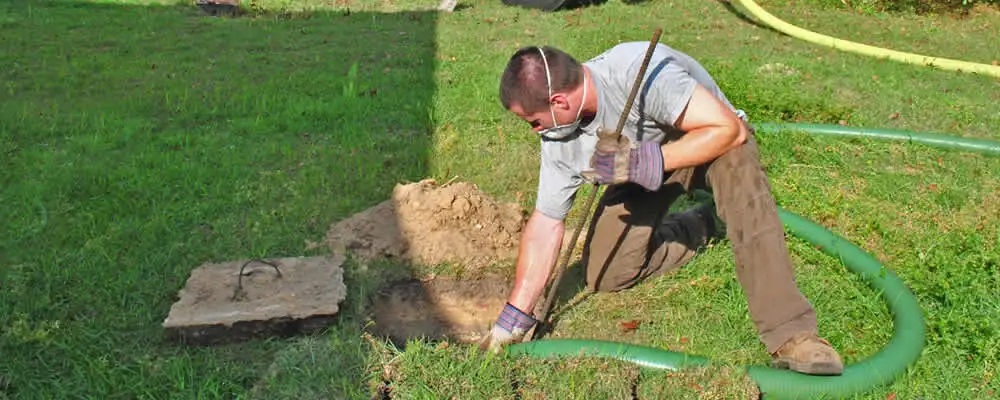 Septic pumping technician servicing a residential septic tank in Virginia Beach, VA