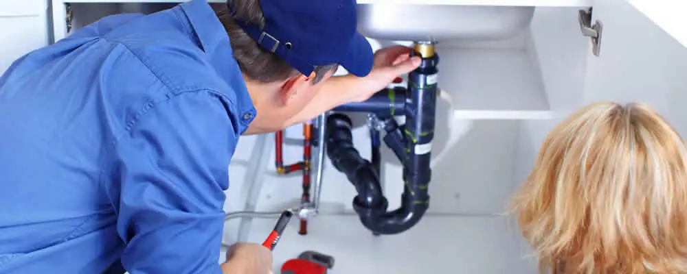 Plumber repairing under-sink drain pipes and fittings in Virginia Beach, VA